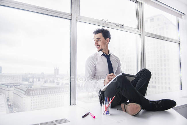 Businessman making notes on pad — Stock Photo