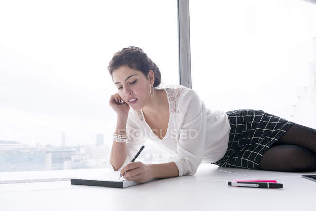 Empresária fazendo anotações no pad — Fotografia de Stock