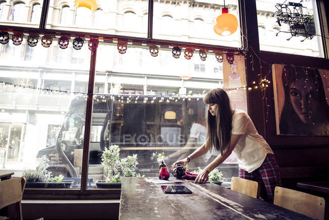 Frau räumt Tisch — Stockfoto