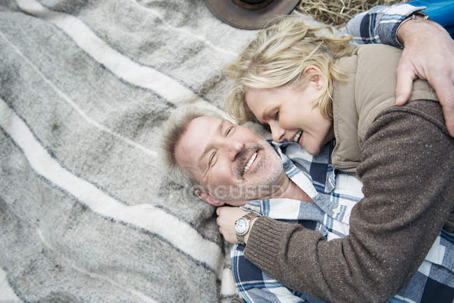 Casal sênior abraçando juntos em cobertor — Fotografia de Stock