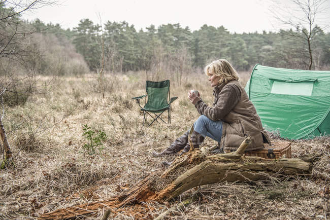 Dame assise appréciant la nature sauvage du camping — Photo de stock