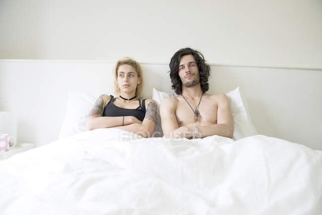 Casal deitado em cama de casal após disputa — Fotografia de Stock