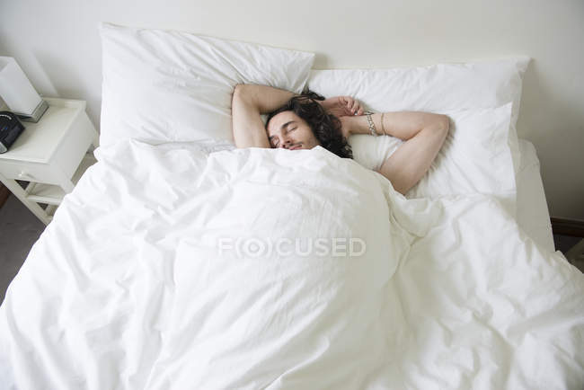 Homme couché au lit — Photo de stock