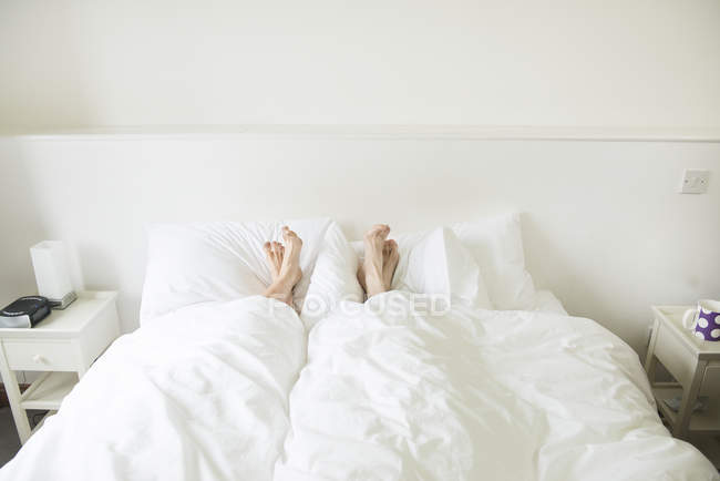 Feet sticking out from underneath covers — Stock Photo