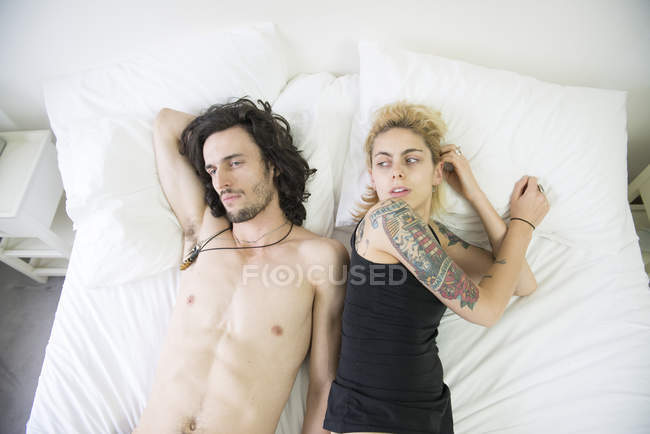 Casal deitado na cama após discussão — Fotografia de Stock