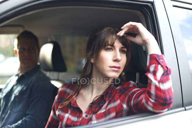 Femme regarde lamentablement par la fenêtre de la voiture — Photo de stock
