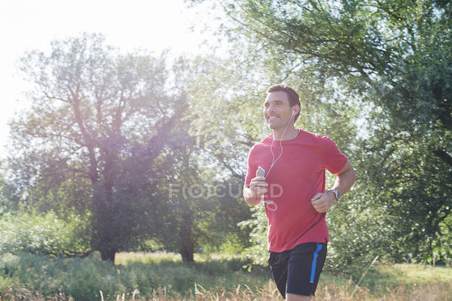 Man jogging through park — Stock Photo