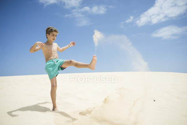 Boy playing in sand dunes — Stock Photo