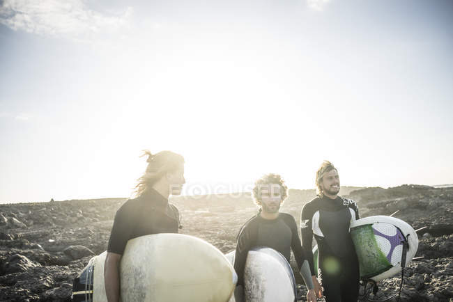 Трое мужчин готовятся к сёрфингу — стоковое фото