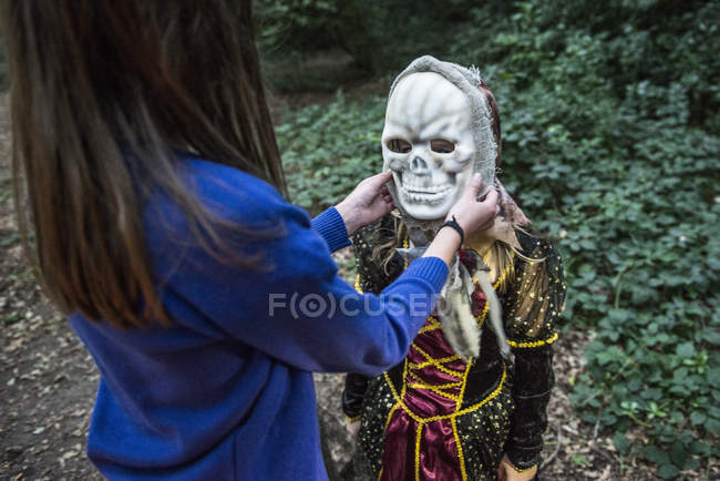 Girl helping friend with costume — Stock Photo