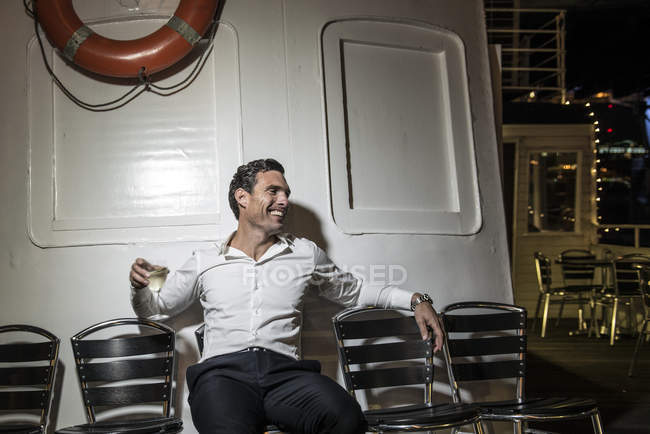 Homem desfrutando de bebida no convés do barco — Fotografia de Stock