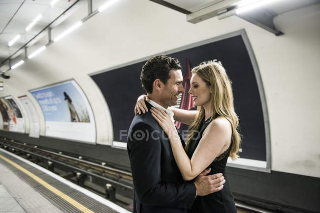 Paar steht kuschelnd auf Bahnsteig — Stockfoto