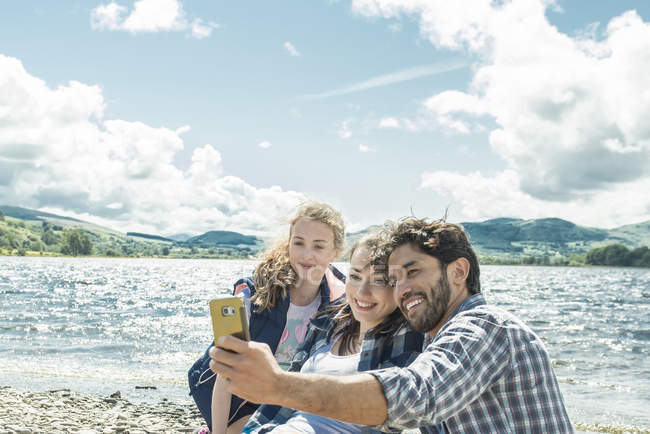 Tres personas tomando selfie en la orilla - foto de stock