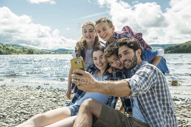 Famiglia prendendo selfie sulla riva — Foto stock