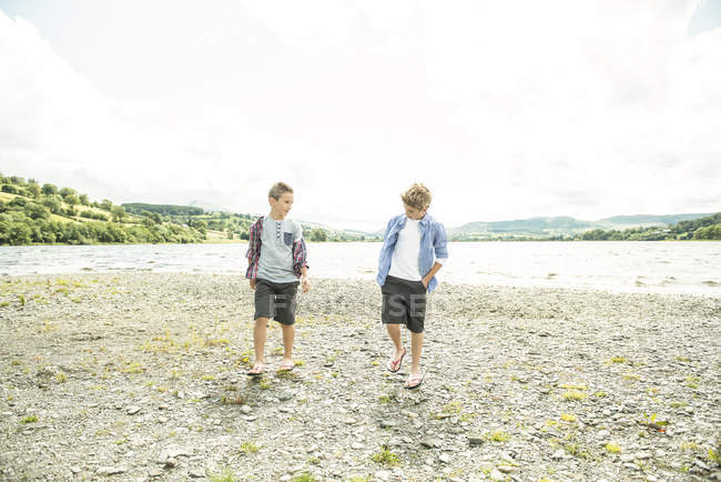 Due ragazzi che camminano sulla riva — Foto stock
