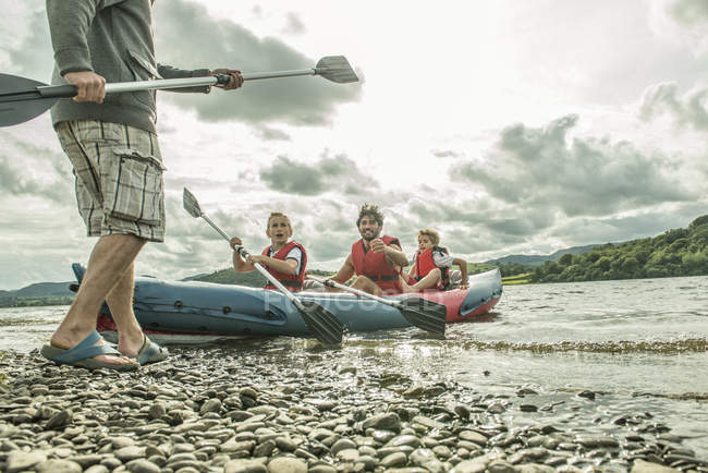Uomo e due ragazzi in kayak remare via — Foto stock
