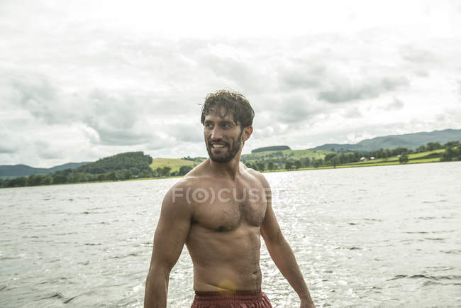 Mann mit nacktem Oberkörper steht im Wasser — Stockfoto