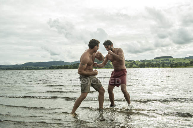 Men boxing in shallow water — Stock Photo