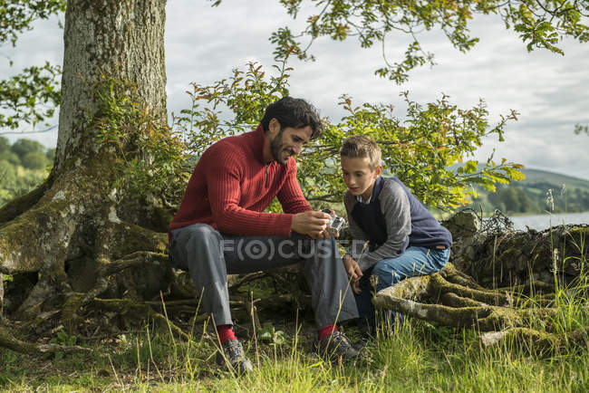 Мужчина показывает сыну, как пользоваться камерой — стоковое фото