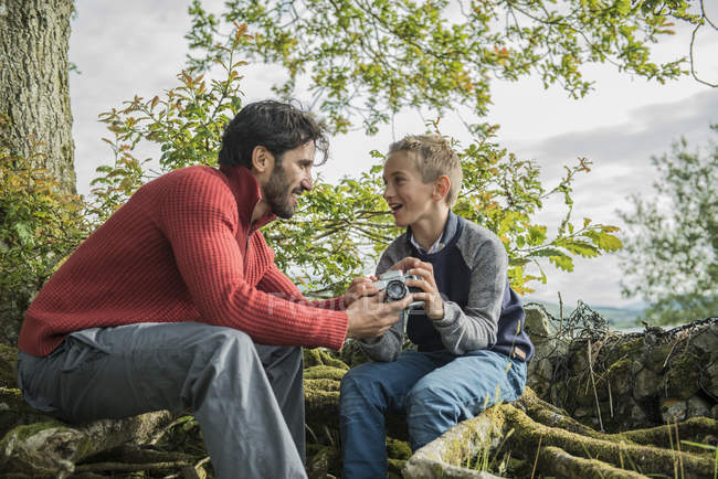 Мужчина показывает сыну, как пользоваться камерой — стоковое фото