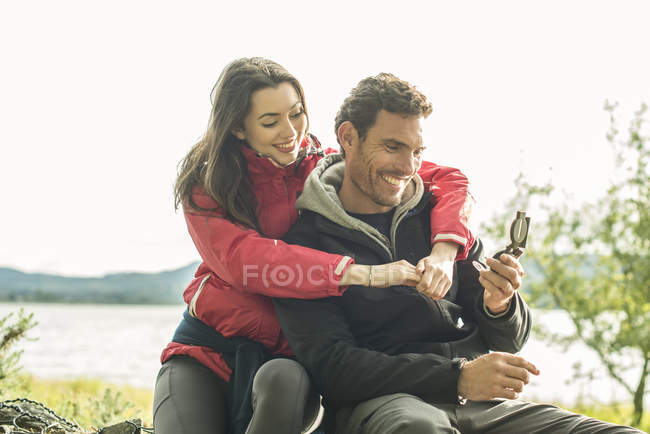 Man and woman using compass — Stock Photo