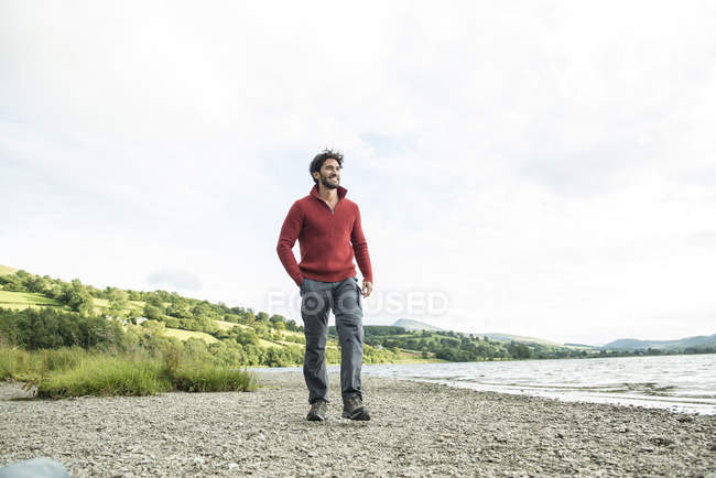 Hombre en puente rojo de pie en la orilla - foto de stock