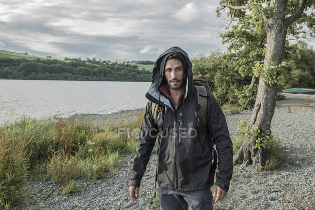 Man in hiking clothes walking on shore — Stock Photo