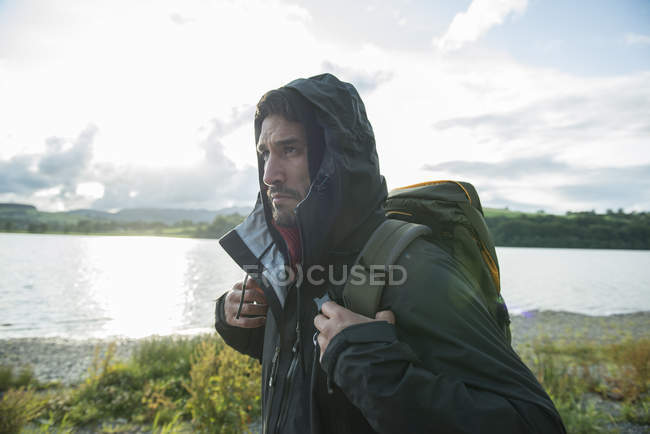 Man in hiking clothes walking on shore — Stock Photo