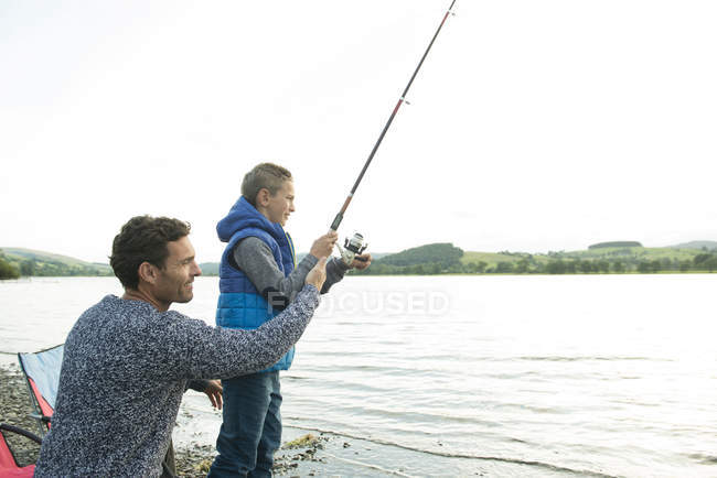Батько і син рибалка з берега — стокове фото