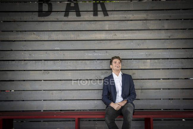 Mann sitzt auf Bank hinter Bar — Stockfoto