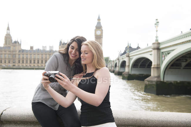 Two friends looking at photographs on South Bank — Stock Photo