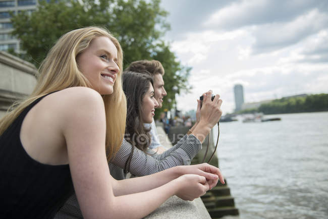 Three friends taking photographs on South Bank — Stock Photo