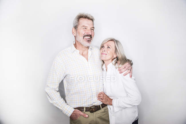 Casal abraçando e sorrindo para a câmera — Fotografia de Stock