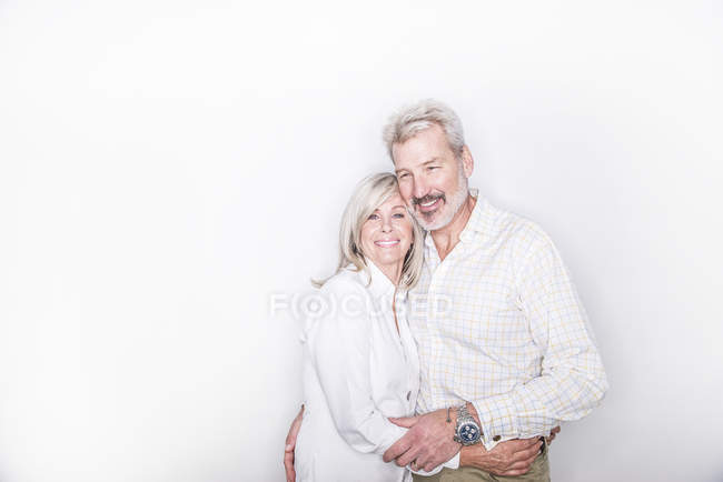 Couple étreignant et souriant à la caméra — Photo de stock