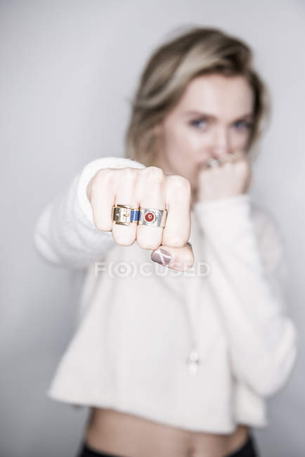 Attractive woman holding out fist — Stock Photo