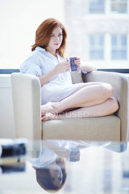 Mulher de camisa branca bebe café da manhã — Fotografia de Stock