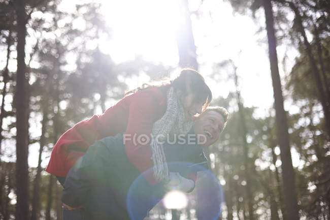 Homem dá fêmea parceiro piggyback passeio — Fotografia de Stock