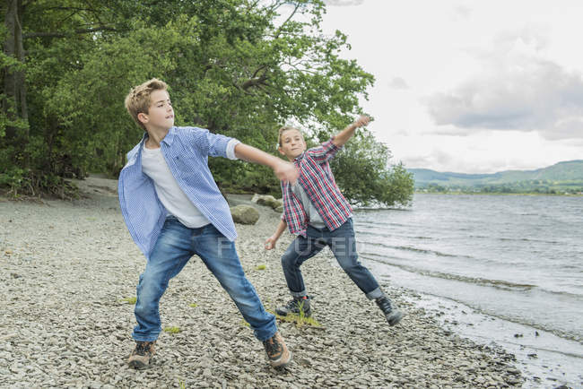 Dos chicos jugando en la orilla - foto de stock
