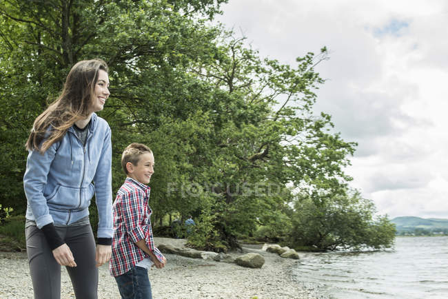 Mujer y niño jugando en la orilla - foto de stock
