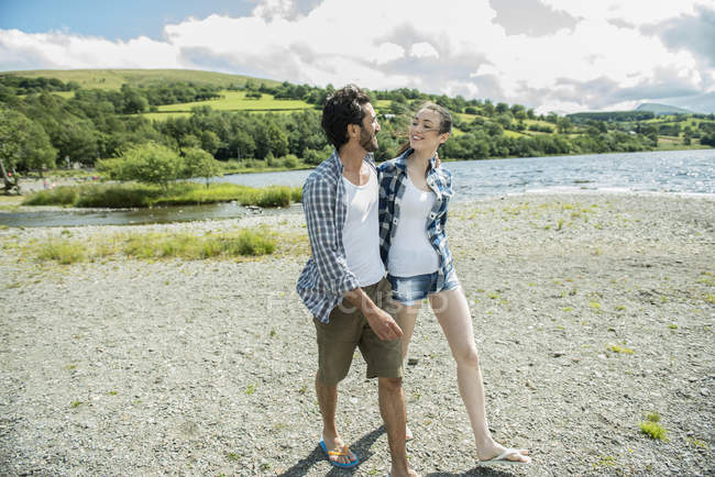 Uomo e donna che camminano sulla riva — Foto stock