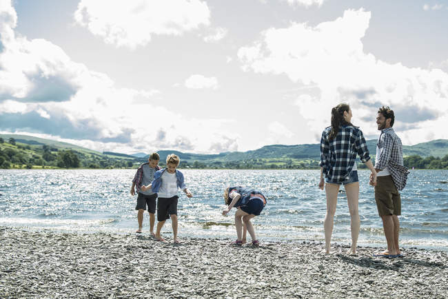 Family of five standing on shore — Stock Photo