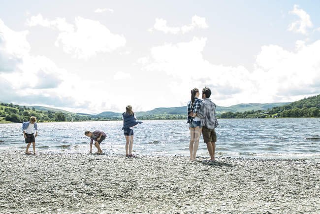 Семья, стоящая на берегу — стоковое фото