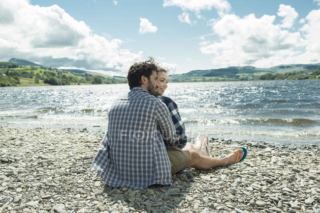 Uomo e donna seduti sulla riva — Foto stock