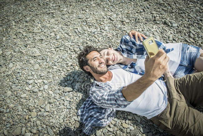 Homme et femme prenant selfie sur la rive — Photo de stock