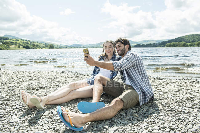 Чоловік і жінка, беручи selfie берег — стокове фото
