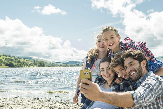 Famiglia prendendo selfie sulla riva — Foto stock