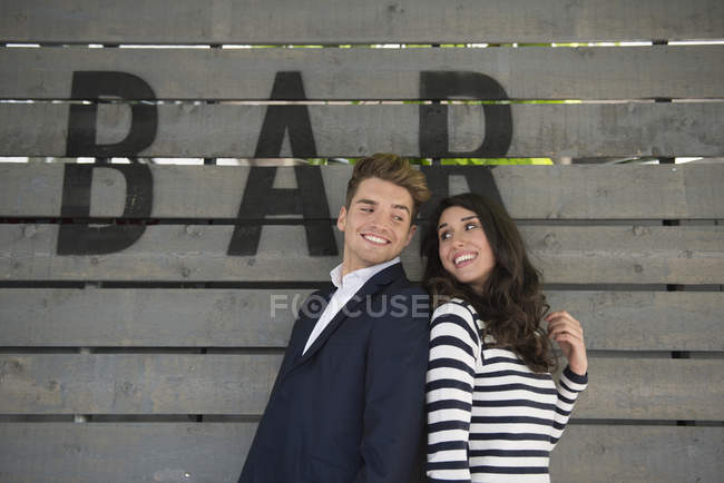 Casal em pé no banco atrás da barra — Fotografia de Stock