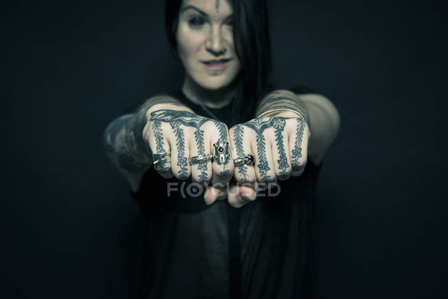 Retrato de mujer con brazos y cara tatuados - foto de stock