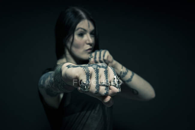 Portrait of woman with tattooed arms and face — Stock Photo