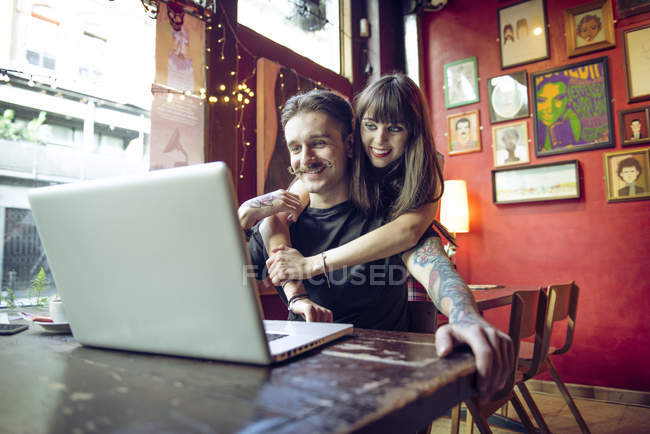 Couple travaillant à l'ordinateur portable dans un café — Photo de stock